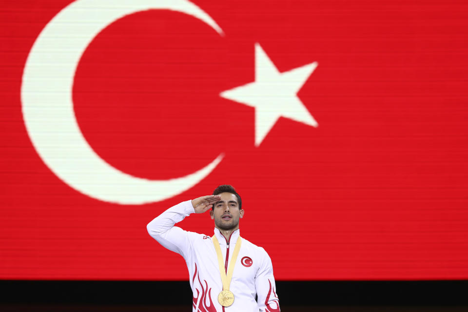 Gold medalist on the rings Ibrahim Colak of Turkey celebrates on the podium after the men's apparatus finals at the Gymnastics World Championships in Stuttgart, Germany, Saturday, Oct. 12, 2019. (AP Photo/Matthias Schrader)