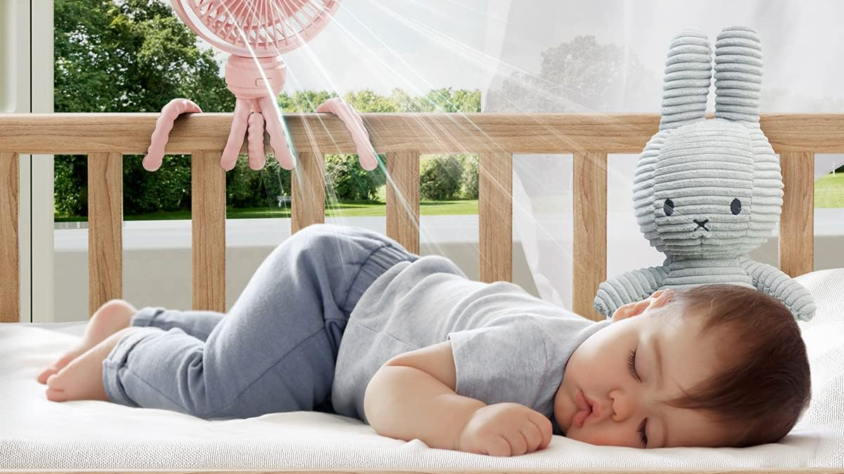 a baby lying on a bed with a large balloon on its head