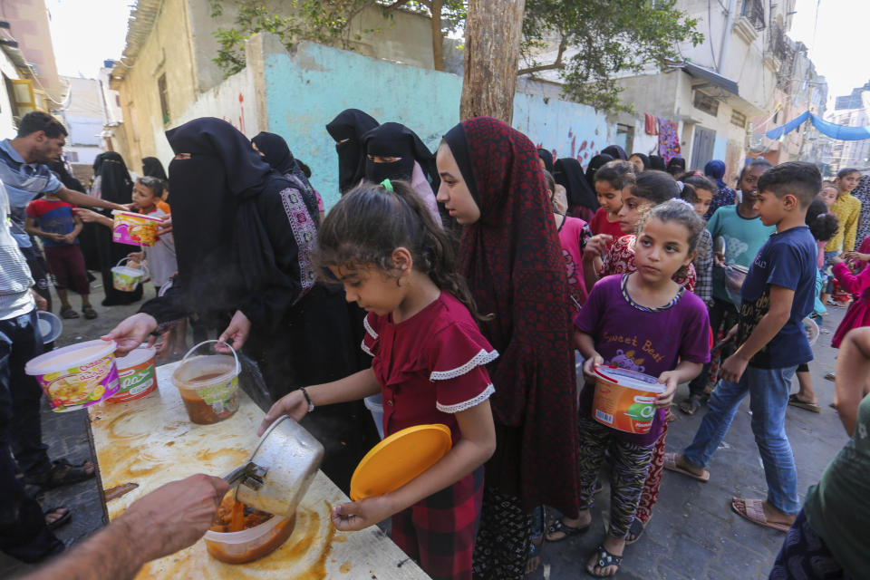 Palestinians receive food in Rafah, southern Gaza Strip, Wednesday, Nov. 8, 2023. Since the start of the Israel-Hamas war, Israel has limited the amount of food and water allowed to enter the territory, causing widespread hunger across the strip (AP Photo/Hatem Ali)