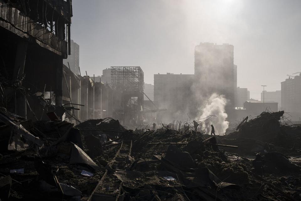 Feuerwehrleute löschen ein Feuer in der Nähe eines Einkaufszentrums nach Beschuss in Kiew, Ukraine, 21. März 2022.