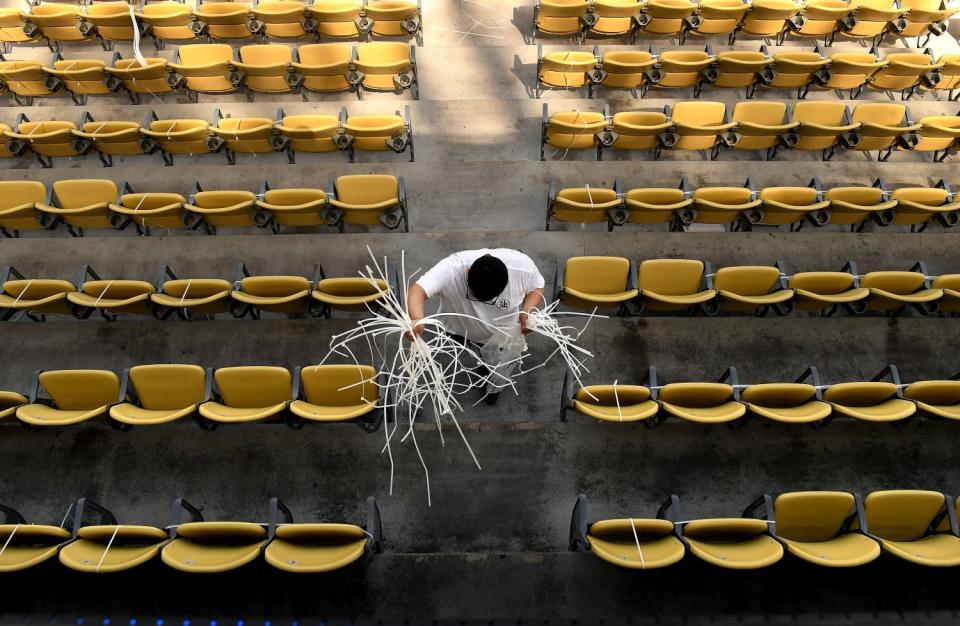 A work crew member carries zip ties to fold seats