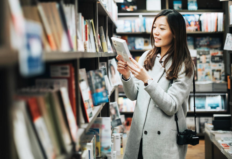 Young woman enjoying a quiet time reading book in book store (Getty Images)