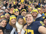 In a photo provided by Melissa Hutchinson, Aidan Hutchinson takes a selfie with family and fans after Michigan's win over Ohio State on Nov. 27, 2021, in Ann Arbor, Mich. Jacksonville is expected to select Hutchinson with the No. 1 pick in the NFL draft on Thursday night, April 28. It's easy to see why the Jaguars would want him after watching what Hutchinson did last year at Michigan. Scouts who searched for more about his background found out Chris and Melissa raised a well-rounded son, uniquely shaped by a close-knit family that includes two older sisters. (Aidan Hutchinson via AP)