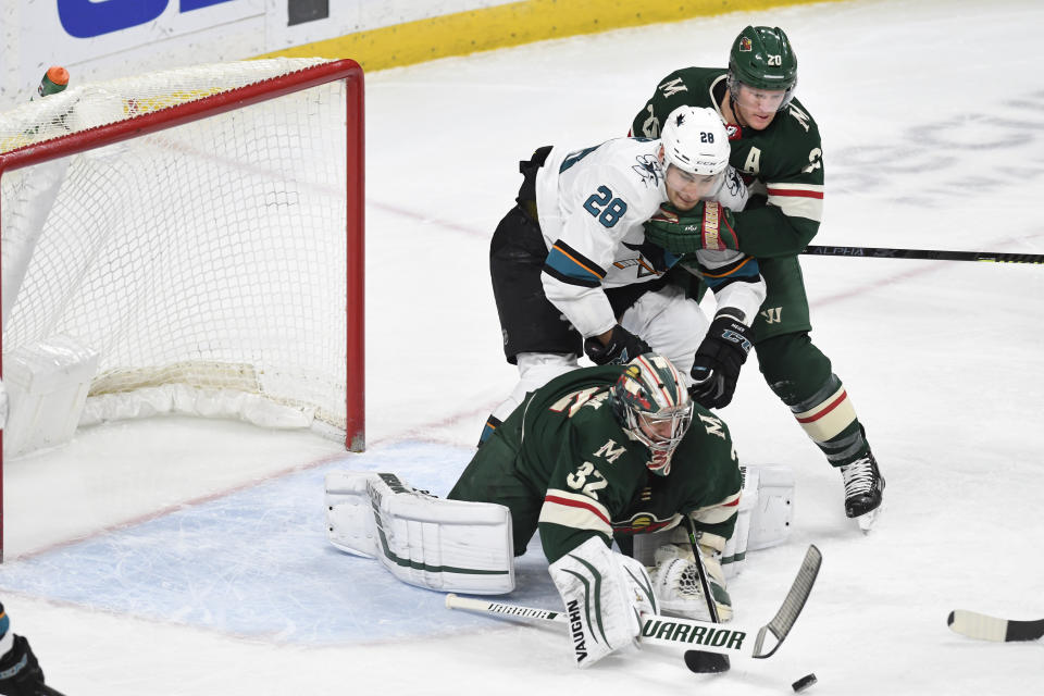 Minnesota Wild's Ryan Suter, right, holds off the San Jose Sharks' Timo Meier (28), of Switzerland, as the Wild's goalie Alex Stalock makes a save in the first period of an NHL hockey game, Saturday, Feb. 15, 2020, in St. Paul, Minn. (AP Photo/Tom Olmscheid)