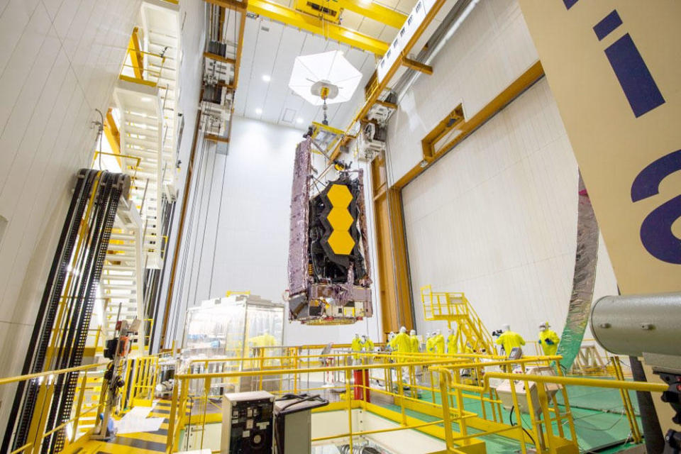 The telescope, its sunshade, solar array and optical elements folded up for launch, is moved into place for attachment to a European Space Agency Ariane 5 rocket. / Credit: NASA