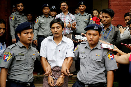 FILE PHOTO: Detained Reuters journalist Kyaw Soe Oo and Wa Lone are escorted by police as they leave after a court hearing in Yangon, Myanmar, August 20, 2018. REUTERS/Ann Wang/File Photo