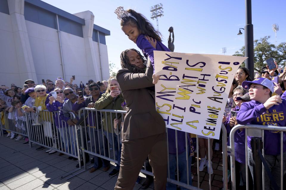 Seimone Augustus, a former LSU player who lead her team to multiple final fours and a Minnesota Lynx player who won four WNBA Championships, picks a young fan out of the crowd before her statue unveiling at the LSU campus on Sunday, Jan. 15, 2023, in Baton Rouge, La. (AP Photo/Matthew Hinton)