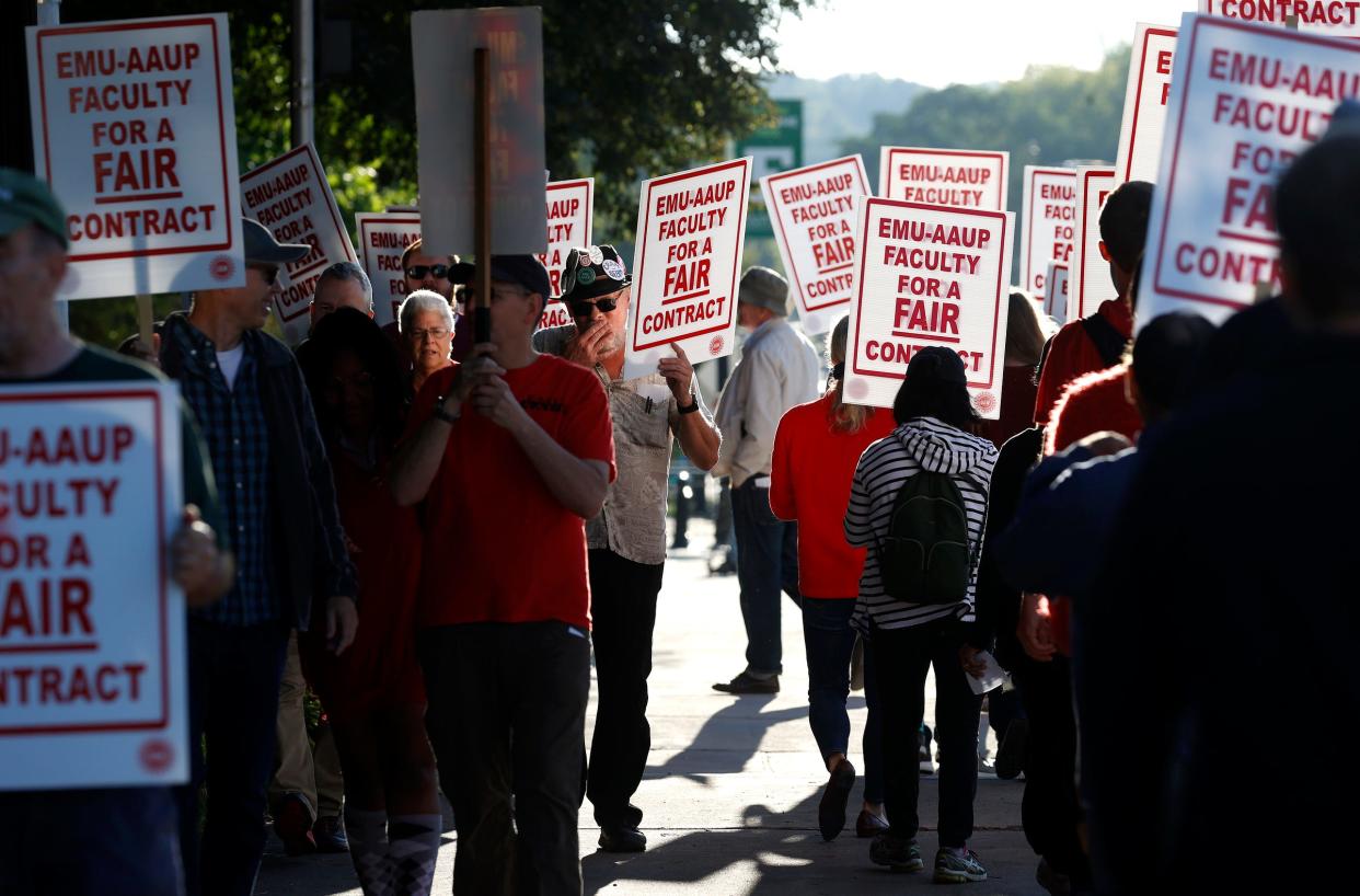 Eastern Michigan University faculty walk up and down the sidewalk in front of Welch Hall, the schools administration building on Wednesday, Sept. 7, 2022, after they voted on Tuesday night to strike.