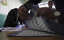 Afghan election workers count ballots during the parliamentary elections, at a polling station in Kabul, Afghanistan, Sunday, Oct. 21, 2018. The elections entered a second day after delays caused by violence and technical issues, as a roadside bomb killed nearly a dozen civilians on Sunday, including several children. (AP Photo/Rahmat Gul)