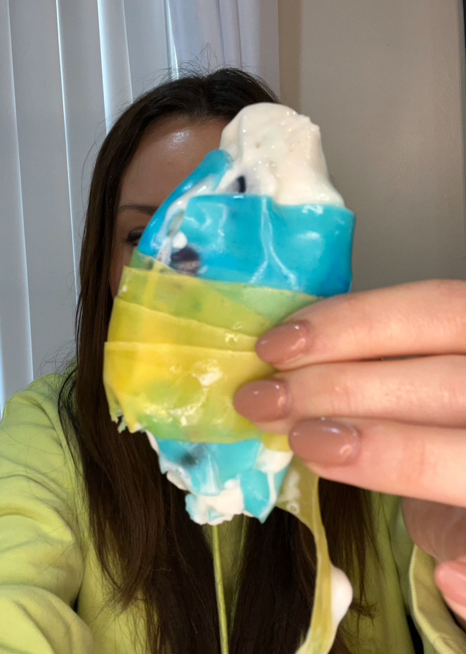 Woman holding the Fruit by the Foot wrapped around the Fruit Roll-Up in front of her face