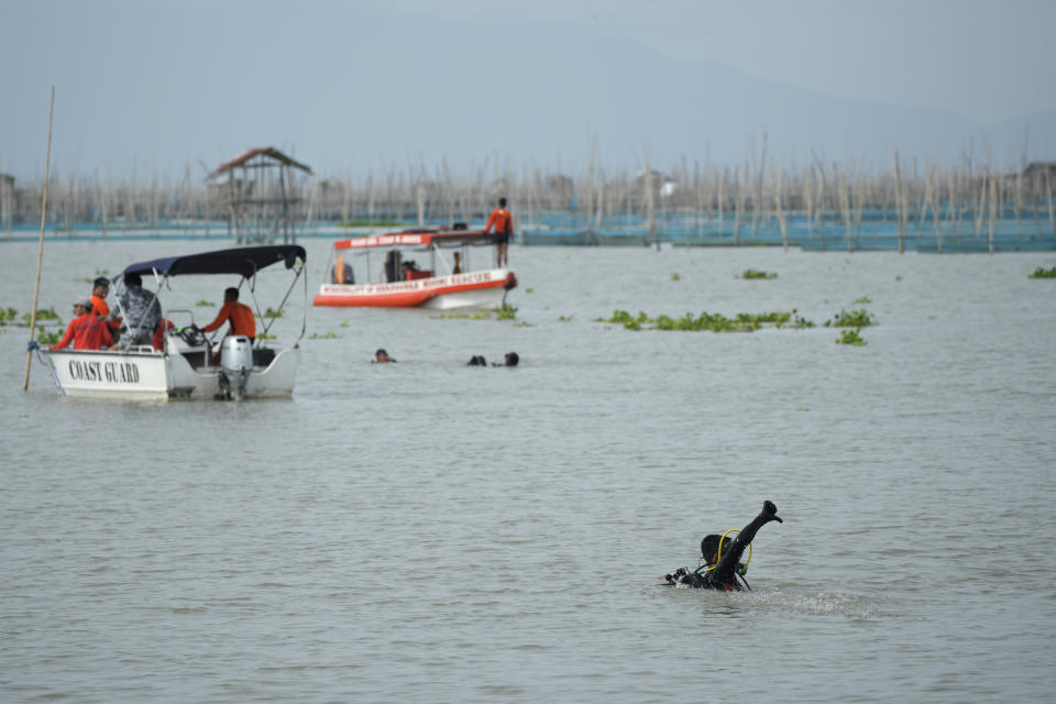 Rescuers search for victims of a capsized ferry in Binangonan, Rizal province, Philippines, Friday, July 28, 2023. The boat turned upside down when passengers suddenly crowded to one side in panic as fierce winds pummeled the wooden vessel, killing a number of people, officials said Friday. (AP Photo/Aaron Favila)