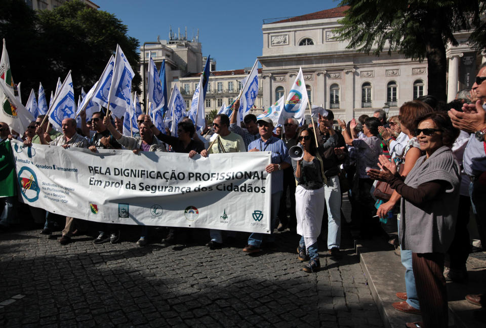 People applaud members of the Portuguese police professionals association joining a workers unions' demonstration in Lisbon, Saturday, Sept. 29 2012. Thousands of Portuguese people , enduring deep economic pain from austerity cuts , took to the streets Saturday in protest. The banner reads, "For dignity of the profession. In favor of the citizen's security. ". (AP Photo/Armando Franca)
