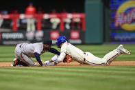 Philadelphia Phillies' Nick Castellanos, right, is tagged out at second base by Atlanta Braves' Ozzie Albies during the fourth inning of a baseball game Sunday, March 31, 2024, in Philadelphia. (AP Photo/Derik Hamilton)