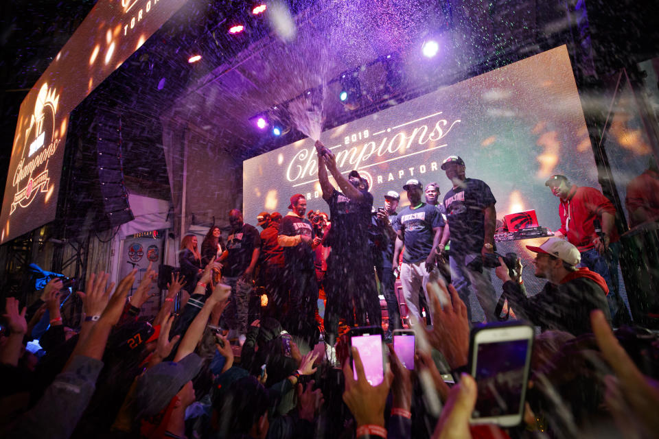 TORONTO, ON - JUNE 13: Toronto rapper Drake sprays the crowd with champaign as Toronto Raptors beat the Golden State Warriors in Game Six of the NBA Finals, during a viewing party in Jurassic Park outside of Scotiabank Arena on June 13, 2019 in Toronto, Canada. (Photo by Cole Burston/Getty Images)