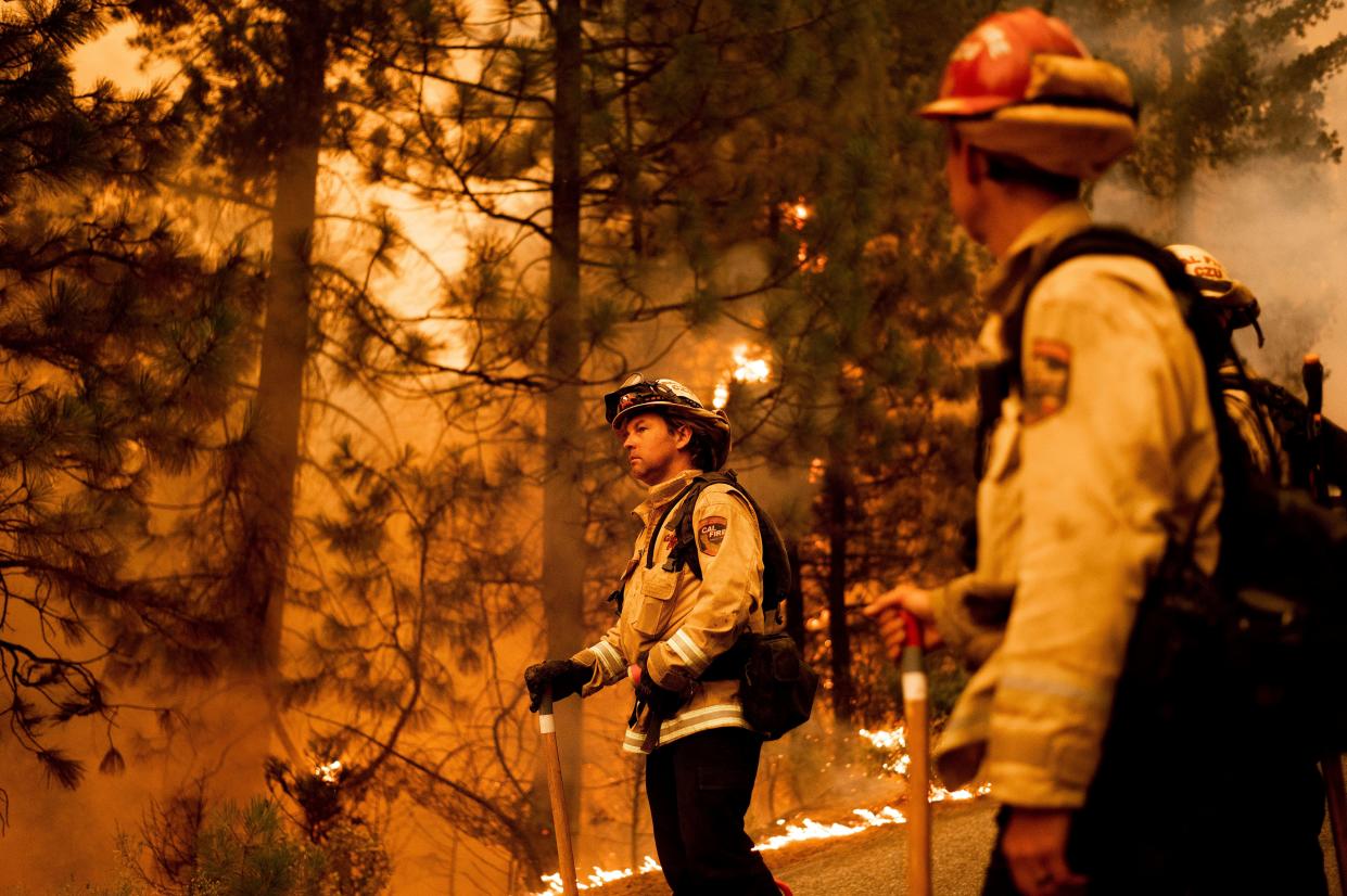 Firefighter Jason Prado monitors flames as his crew burns vegetation to stop the Dixie Fire from spreading near Prattville in Plumas County, Calif. on Friday, July 23, 2021.