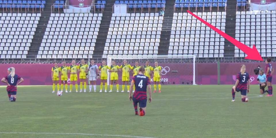 Carli Lloyd stands as her USWNT teammates kneel to protest racism.