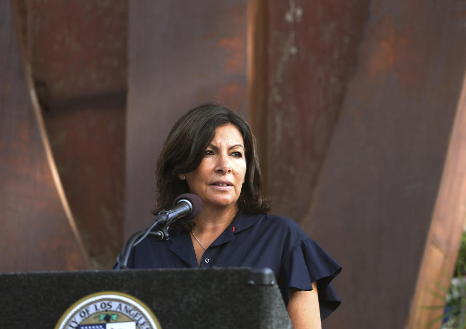 Paris Mayor Anne Hidalgo speaks during a ceremony marking the 17th anniversary of the Sept. 11, 2001 terrorist attacks on the United States, at the Los Angeles Fire Department's training center Tuesday, Sept. 11, 2018. In the background is the largest fragment of the World Trade Center outside New York. (AP Photo/Reed Saxon)