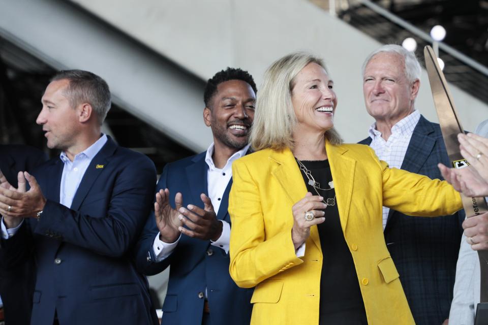 Crew investor-operator Dee Haslam, center, smiles after a ribbon-cutting ceremony at Lower.com Field. Also pictured are, from left, Crew coach Caleb Porter, Franklin County Commissioner Kevin Boyce and investor-operator Jimmy Haslam.