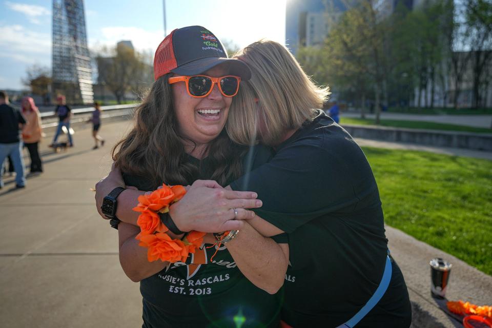 Missy Bohannon (left) receives a hug from Jen Kirchhofer before their fundraising team, Rosie's Rascals, participates in a 1-mile Walk MS route at White River State Park.