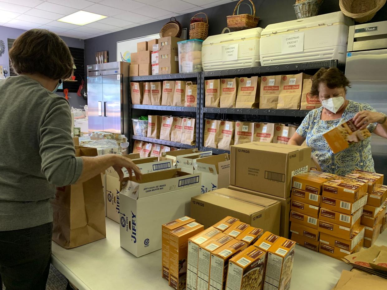 Volunteers sort food donations collected as part of Two Men and a Truck's Movers for Meals program. More than 400 low-income seniors will receive a Thanksgiving meal through the program this season.