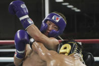 Japanese boxer and the WBA and IBF bantamweight world champion Naoya Inoue, left, trains at the Ohashi Boxing Gym in Yokohama, near Tokyo on Nov. 23, 2021. Drawing praise as one of the best "pound for pound" active boxers around, and the best out of Asia since the legendary Manny Pacquiao, Inoue now has his eyes on the big money and American stardom. (AP Photo/Koji Sasahara)