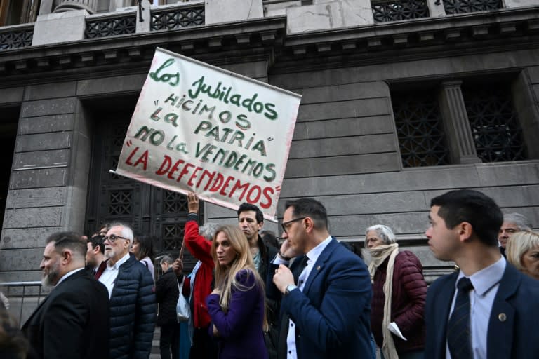 Un hombre muestra una pancarta rechazando el veto del presidente de Argentina, Javier Milei, de la ley para aumentar las jubilaciones, el 4 de septiembre de 2024 frente al Congreso, en Buenos Aires (Luis Robayo)