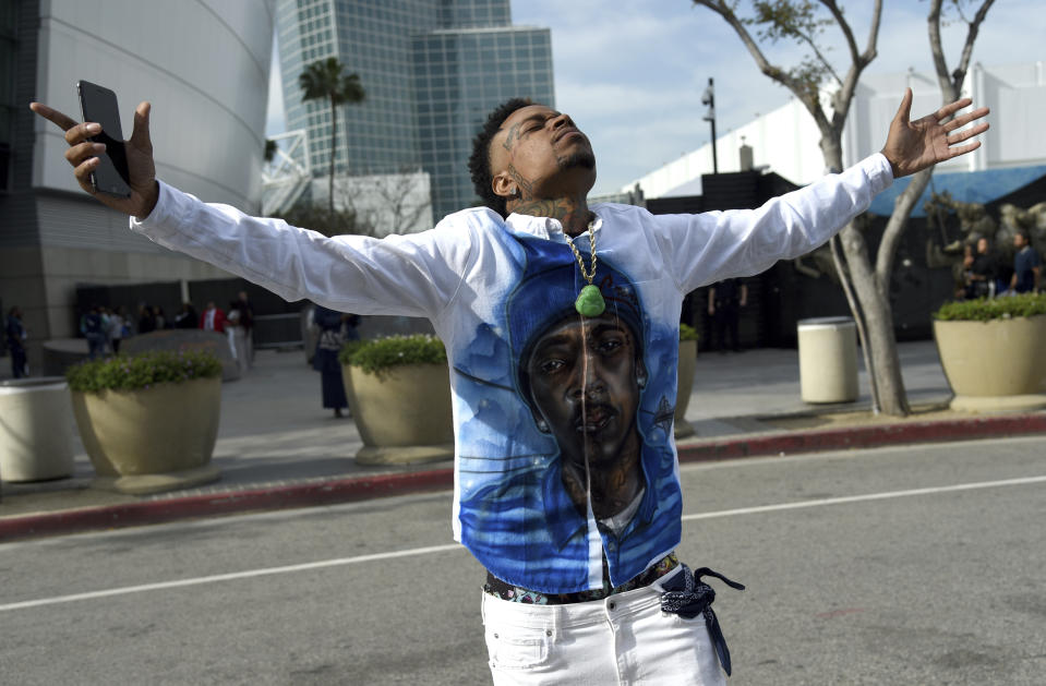 Slum Baby, of the Crenshaw neighborhood of Los Angeles, gestures to the sky as he attends the Celebration of Life memorial service for late rapper Nipsey Hussle, whose given name was Ermias Asghedom, on Thursday, April 11, 2019, at the Staples Center in Los Angeles. (Photo by Chris Pizzello/Invision/AP)