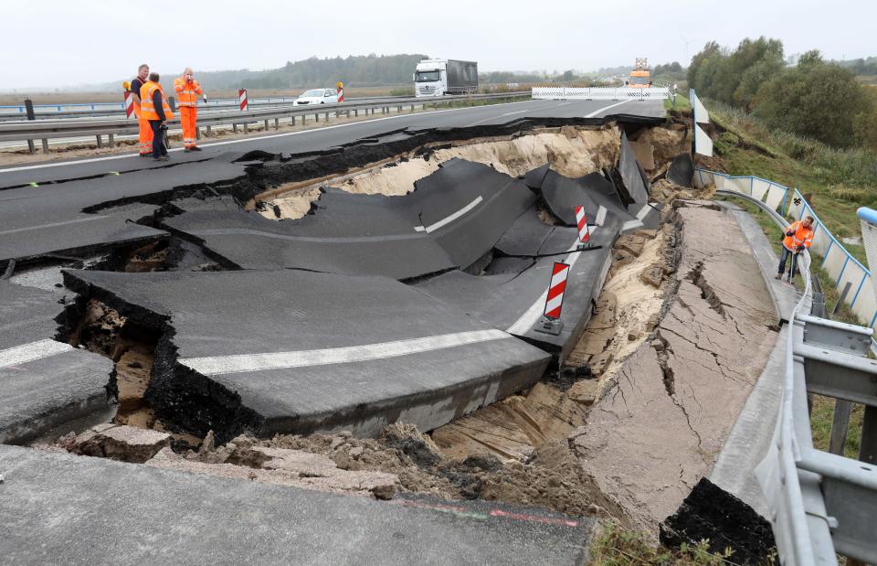 Experts inspect the cut-off section of the A20 motorway at the site of an unexplained landslide near Tribsees in northern Germany on&nbsp;Oct. 10, 2017.
