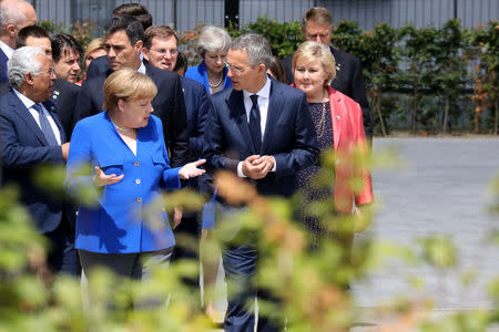 German Chancellor Angela Merkel speaks with NATO Secretary General Jens Stoltenberg as they arrive for a family picture ahead of the opening ceremony of the NATO (North Atlantic Treaty Organization) summit, at the NATO headquarters in Brussels, Belgium, July 11, 2018. Ludovic Marin/Pool via REUTERS