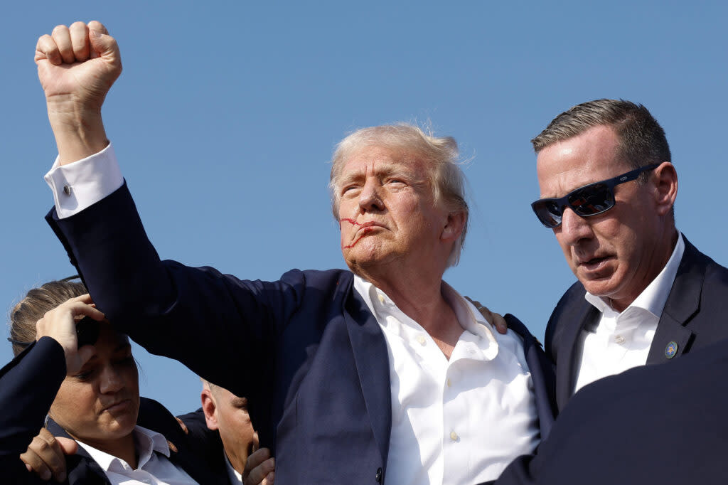 Republican presidential candidate former President Donald Trump pumps his fist as he is rushed offstage during a rally on July 13, 2024 in Butler, Pennsylvania. (Photo by Anna Moneymaker/Getty Images)