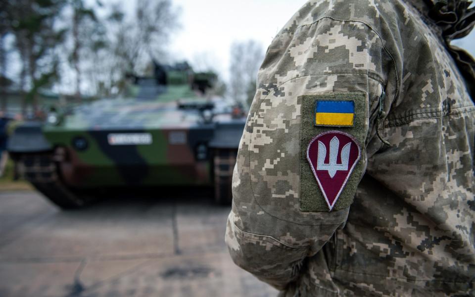 Ukrainian military personnel stand in front of Marder infantry fighting vehicles at the Panzertruppenschule (Tank School) in Munster, Germany