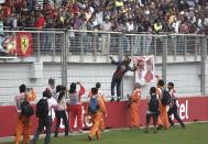 Red Bull Formula One driver Sebastian Vettel of Germany throws his gloves into the crowd after winning the Indian F1 Grand Prix at the Buddh International Circuit in Greater Noida, on the outskirts of New Delhi, October 27, 2013. Vettel became Formula One's youngest four-times world champion on Sunday after winning the Indian Grand Prix for Red Bull. Red Bull also took the constructors' championship for the fourth year in a row. The victory from pole position was the 26-year-old's sixth in a row and completed a hat-trick of wins in India where no other driver has ever won since the race made its debut in 2011. REUTERS/Adnan Abidi (INDIA - Tags: SPORT MOTORSPORT F1)