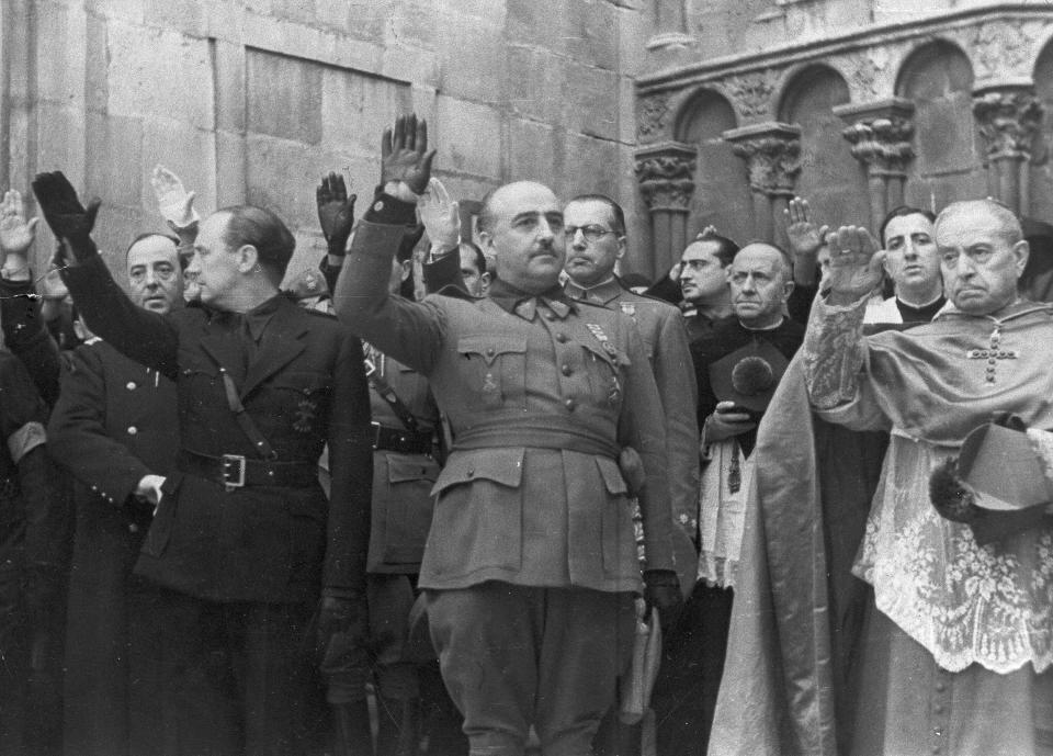 FILE, In this Nov. 20, 1938 file photo, former Spanish dictator Francisco Franco, centre, attends the second anniversary of the death of Jose Antonio Primo de Rivera, the founder of the Spanish right-wing movement La Falange, in Burgos, Spain. After a tortuous judicial and public relations battle, Spain's Socialist government has announced that Gen. Francisco Franco's embalmed body will be relocated from a controversial shrine to a small public cemetery where the former dictator's remains will lie along his deceased wife. (AP Photo)