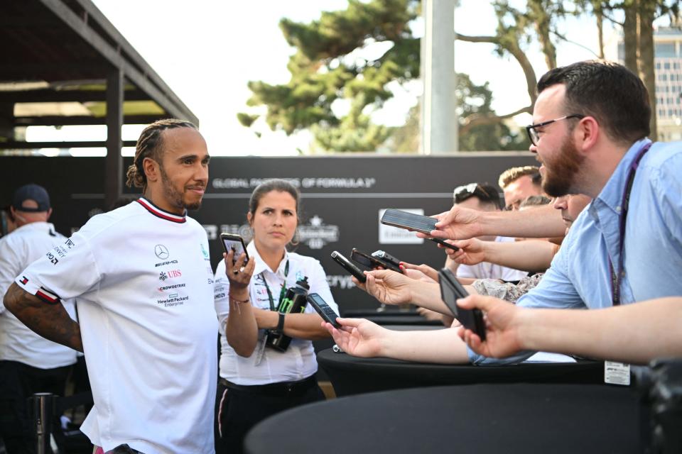 Lewis Hamilton holds his back as he talks to the media (Getty Images)