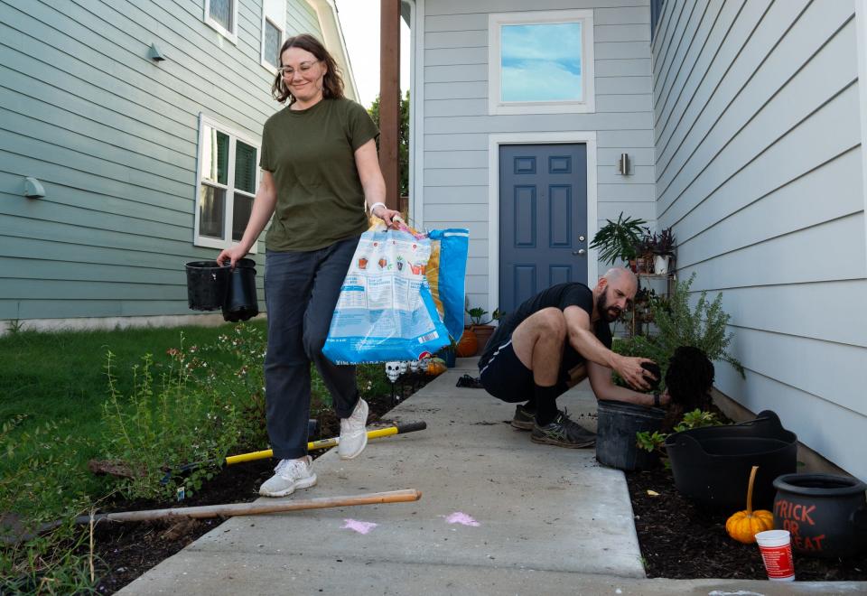 Austin teachers Lauren Vienne, left, and Steven Caplan plant bushes in front of their home last month. The family moved into an East Austin Habitat for Humanity home this summer after the Austin school district sold land to a developer under the condition that 25% of the homes built there would be affordably priced and offered first to teachers and other school workers.