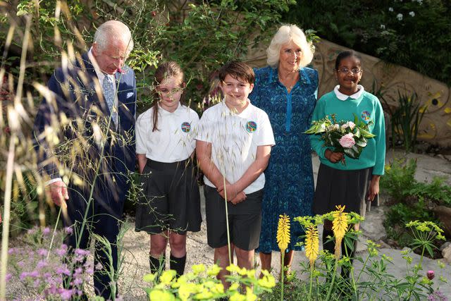 <p>ADRIAN DENNIS/POOL/AFP via Getty</p> King Charles and Queen Camilla with pupils of the Sulivan Primary School at the Chelsea Flower Show on May 20, 2024