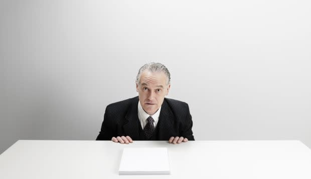 Worried businessman at desk with blank paper