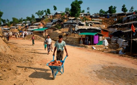 Rohingya refugees who fled to Bangadeshi refugee camps try to reinforce their makeshift homes against expected monsoon rains - Credit: A.M Ahad/AP