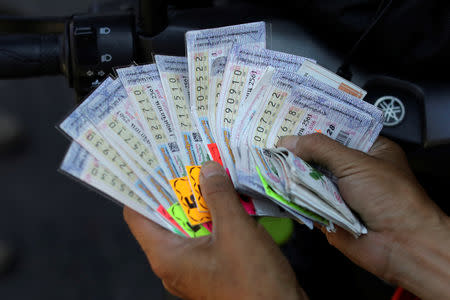 A man shows lottery tickets outside the Wat Kunnatri Ruttharam temple in Bangkok, Thailand November 1, 2018. Picture taken November 1, 2018. REUTERS/Jorge Silva