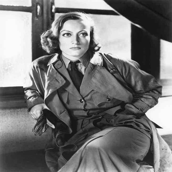 joan crawford sitting in a trench coat