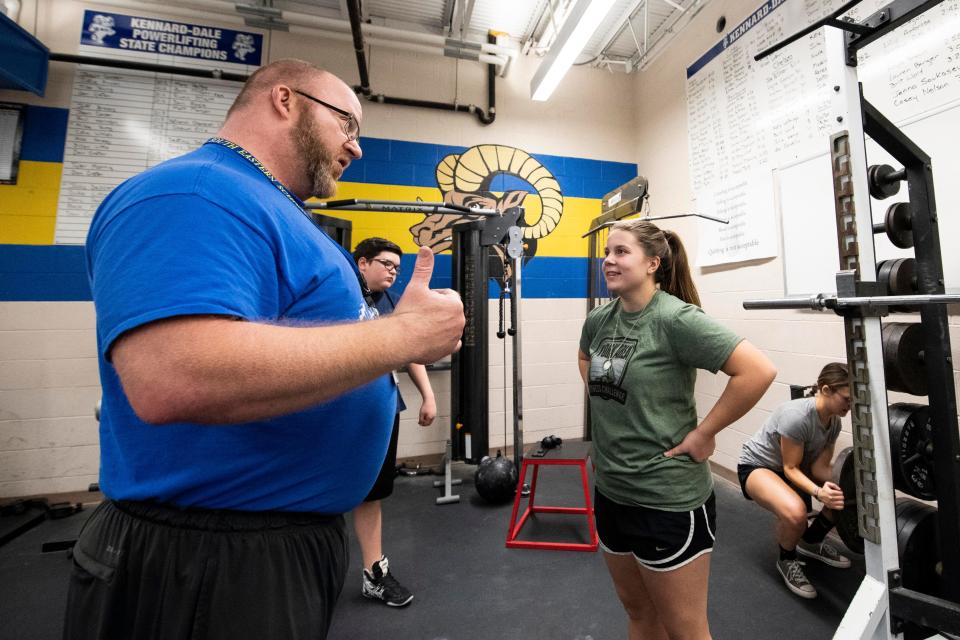 Kennard-Dale powerlifting head coach Niko Hulslander, left, talks to then freshman Hailey Clayton in 2018. The Kennard-Dale powerlifting program had 20 girls on a roster of 74 this past season.