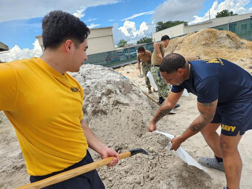 230828-N-YD641-001
JACKSONVILLE, Fla. (Aug. 28, 2023) Culinary Specialist (CS) 2nd Class Juan Rios shovels sand as CS2 Peter Angelade holds the sandbags open to fill at Naval Air Station Jacksonville, Aug. 28. The station has 6,000 bags ready to be filled to help prevent water intrusion from Hurricane Idalia. (U.S. Navy photo by Mass Communications Specialist 2nd Class Matthew Riggs/Released)