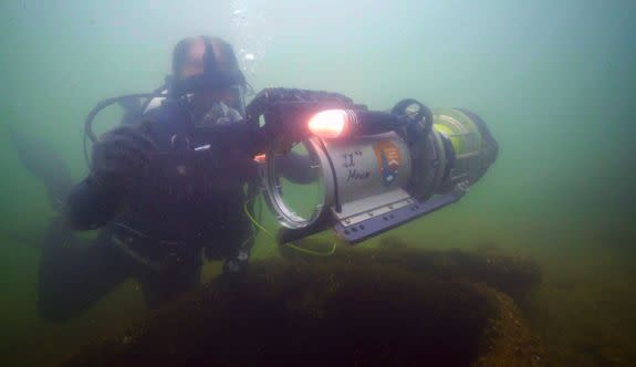 A diver guides a remotely operated vehicle near the USS Arizona site in Pearl Harbor, Hawaii.