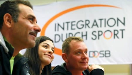 Syrian swimmer Yusra Mardini (C) her father Izzet (L) and coach Sven Spannekrebs of Wasserfreunde Spandau 04 pose during a news conference in Berlin, Germany March 18, 2016. REUTERS/Fabrizio Bensch