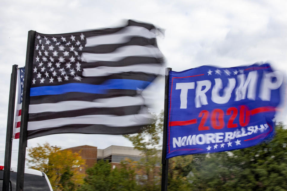 An American flag, a "Back the Blue" flag and a Trump 2020 flag are flown from the back of a truck that is part of the Trump Parade on I-270. (Photo by Stephen Zenner/SOPA Images/LightRocket via Getty Images)