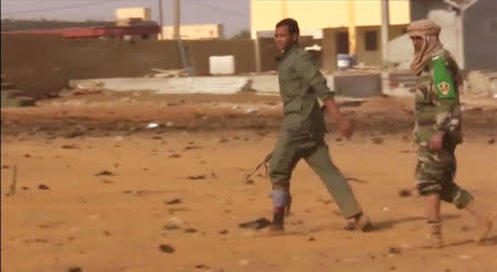 Injured soldiers walk after a suicide car bomb attack on a military camp in Gao, Mali January 18, 2017 in this still image taken from video. REUTERS/via Reuters TV