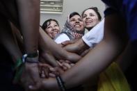 In this Thursday, May 2, 2019 photo, members Hestia FC Women's Refugee Soccer team join hands in a huddle before a friendly game in Athens. Many of the players at Hestia FC weren't allowed to play or even watch soccer matches in their home countries. Hestia FC was set up by the Olympic Truce Centre, a non-government organization created in 2000 by the International Olympic Committee and Greek Foreign Ministry. (AP Photo/Thanassis Stavrakis)