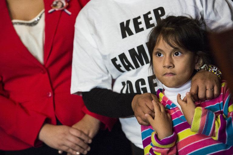 Families from Mexico, now living in Maryland, attend a news conference with Democratic Senators to discuss US President Barack Obama's executive order on immigration, in Washington, DC, on December 10, 2014