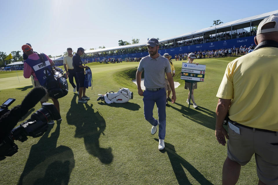 Wyndham Clark walks off the 18th green after making a birdie putt for his team with Beau Hossler to take the lead at the end of the third round of the PGA Zurich Classic golf tournament at TPC Louisiana in Avondale, La., Saturday, April 22, 2023. (AP Photo/Gerald Herbert)