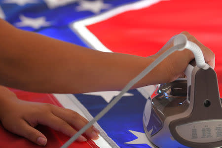 Cynthia Hernandez places stars on a Confederate Battle Flag in the Alabama Flag & Banner shop in Huntsville, Alabama, U.S., August 24, 2017. REUTERS/Harrison McClary